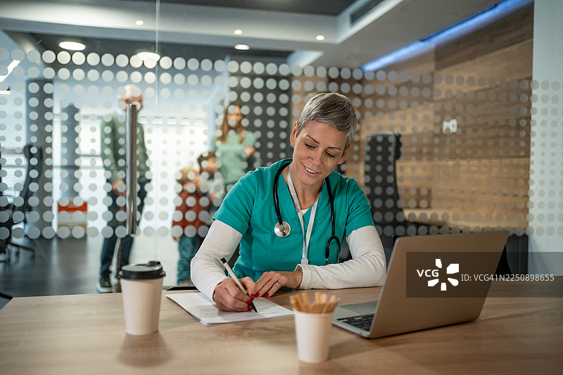 医护人员在办公室用笔记本电脑书写图片素材