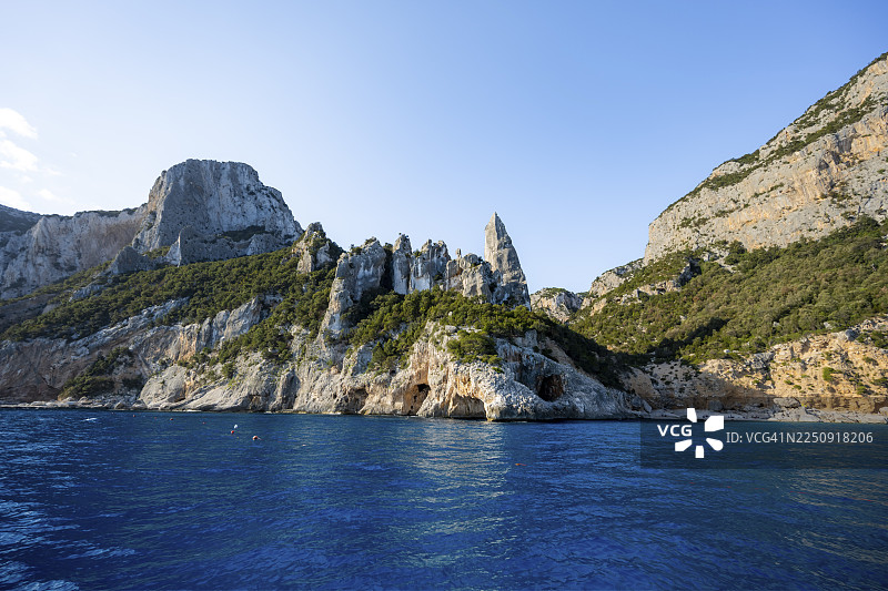 风景如画的岩石海岸，清晨阳光下的悬崖与洞穴，拉古利亚岩石峰，蓝色大海和卡拉戈洛里采海滩，奥罗塞伊湾，巴乌内，撒丁岛，意大利图片素材