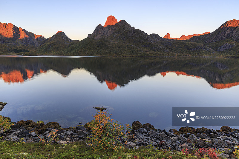 秋日清晨阳光下，安菲尤尔德峡湾映照着韦斯特罗伦群山，挪威图片素材