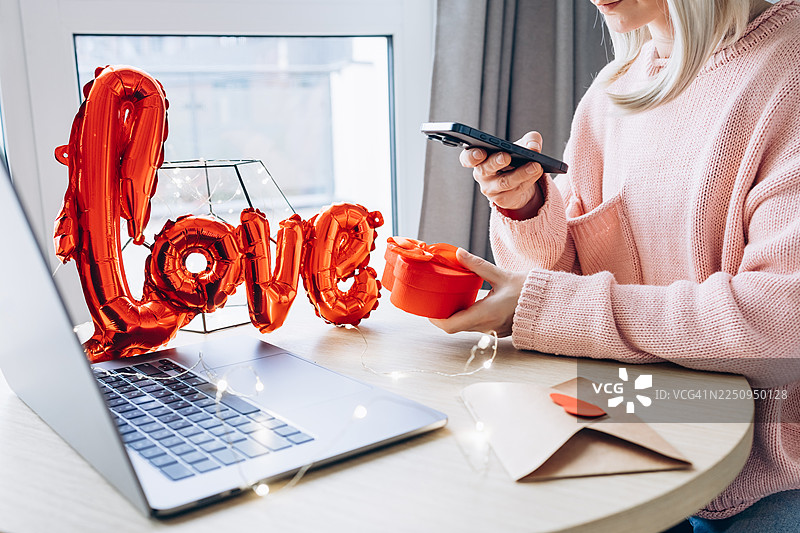 快乐的女人在家享受心形情人节礼物图片素材