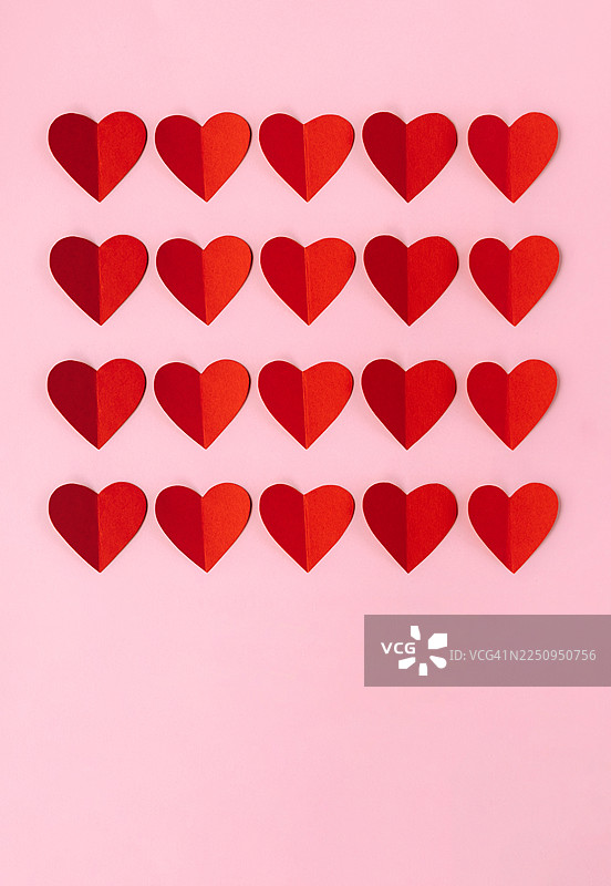 粉色背景上带有红色纸心，极简风格的快乐情人节背景图片素材