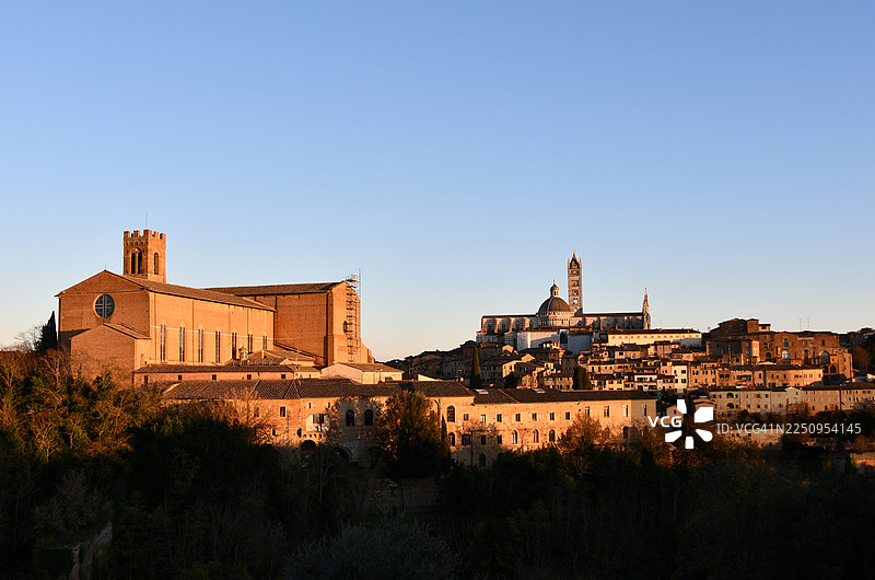 从梅第奇堡垒山拍摄的锡耶纳大教堂和圣多明我大教堂的日落景象。图片素材