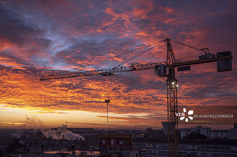 日出时建筑起重机的剪影图片素材