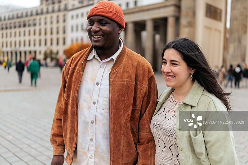 一对幸福的情侣在柏林勃兰登堡门前散步图片素材