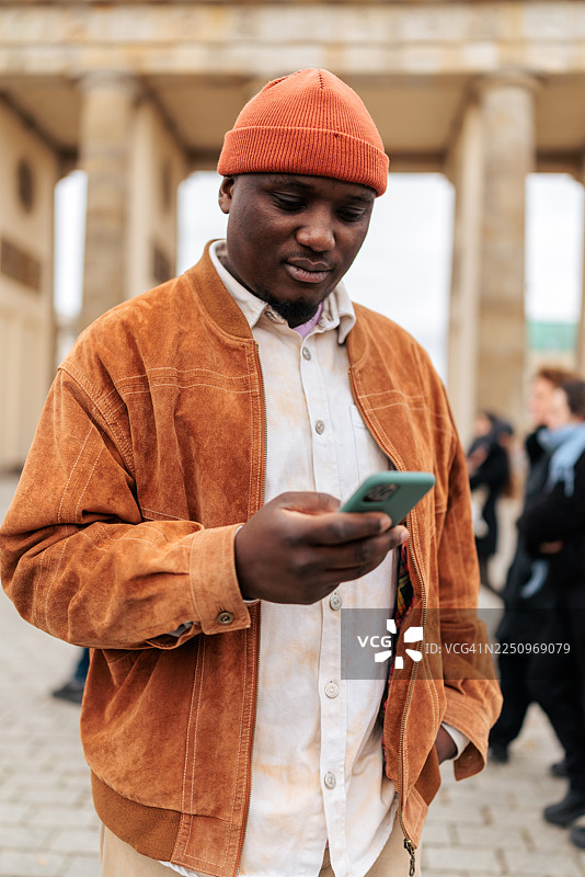 柏林勃兰登堡门前使用智能手机的男人图片素材