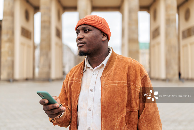 柏林勃兰登堡门前使用智能手机的男人图片素材