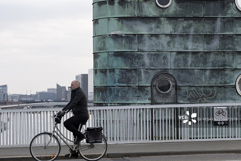 骑行者经过哥本哈根市中心富有纹理的建筑结构图片素材