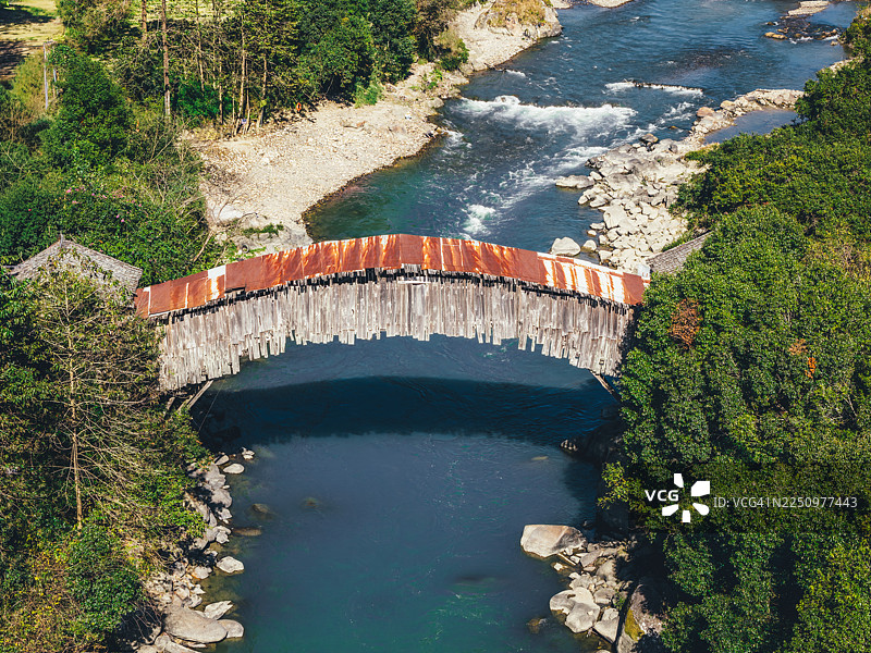 中国云南腾冲野猪峡的叶子青桥，一座横跨河流的乡村木质拱桥，带有生锈的金属屋顶，也称腾冲桥或腾冲桥。图片素材