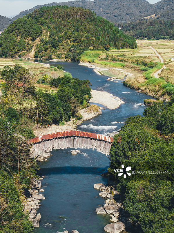 中国云南腾冲的野猪峡悬臂桥，叶竹箐桥，一座横跨流淌河流的乡村木拱桥图片素材