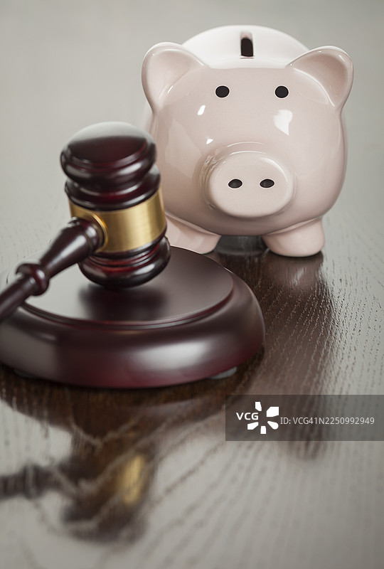 闪亮的木桌上的法槌和存钱罐图片素材