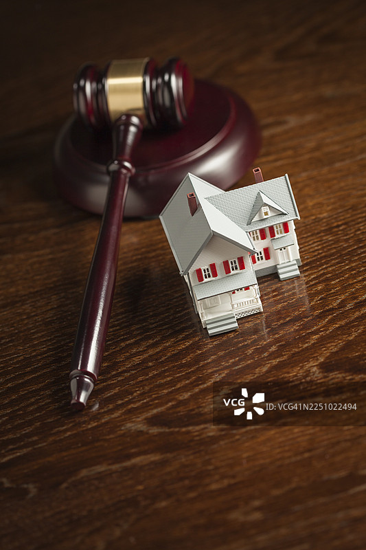 木桌上的法槌和小型模型房屋图片素材