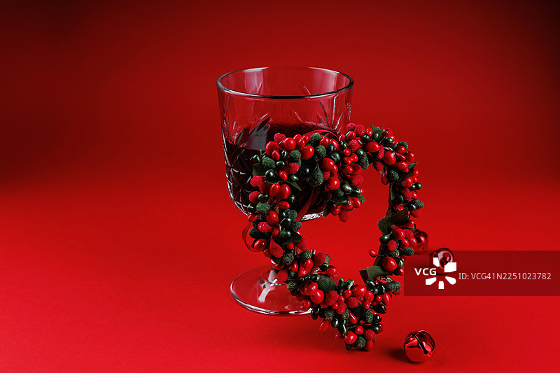 节日红色背景上的心形花环和红酒图片素材