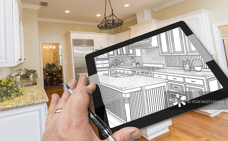 建筑师的手在电脑平板上展示厨房照片后面的图纸图片素材