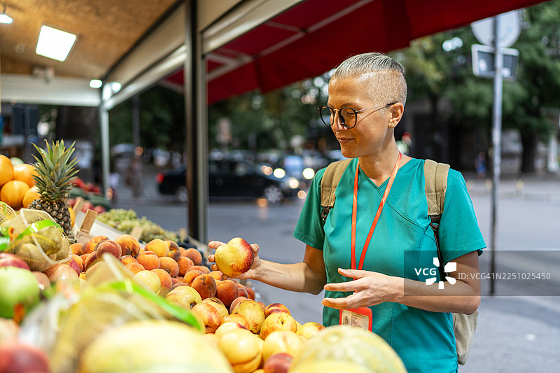 医护人员在当地市场购买新鲜桃子图片素材