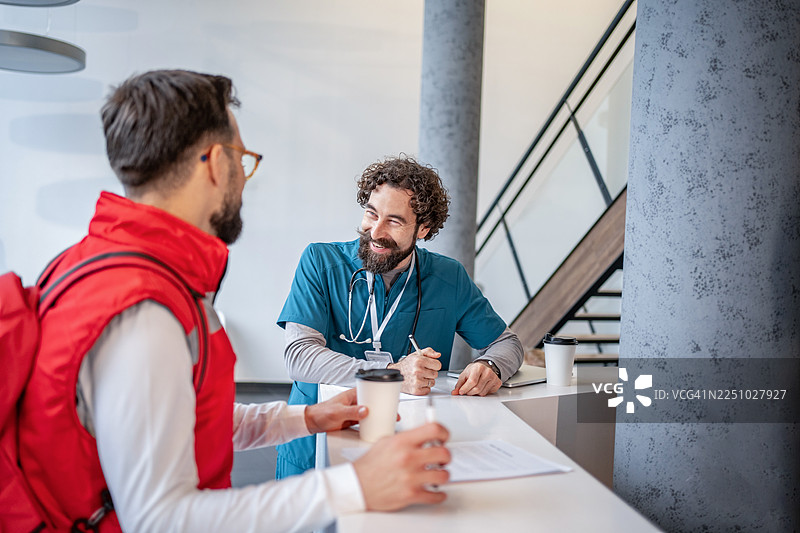 医护人员在医院接待处与患者交谈图片素材