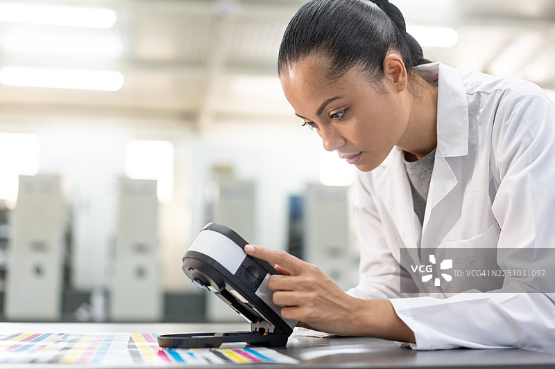 女技术员在印刷厂使用分光光度计进行色彩打样图片素材