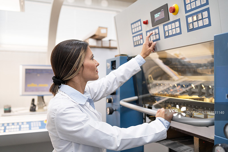 一位女性在生产行业的印刷机上工作图片素材