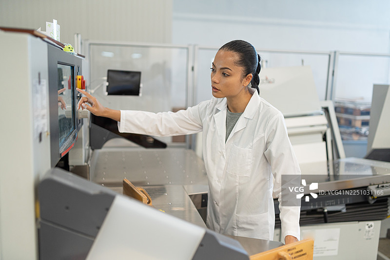 女工在工厂操作工业印刷机械图片素材