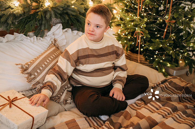 患有唐氏综合征的男孩在家拆圣诞礼物图片素材