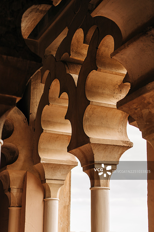 质朴的摩尔式拱门柱，带有重复的拱形和柔和的晚间光线，背景为乡村环境图片素材