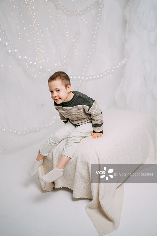 快乐的自闭症小男孩在室内坐着微笑图片素材