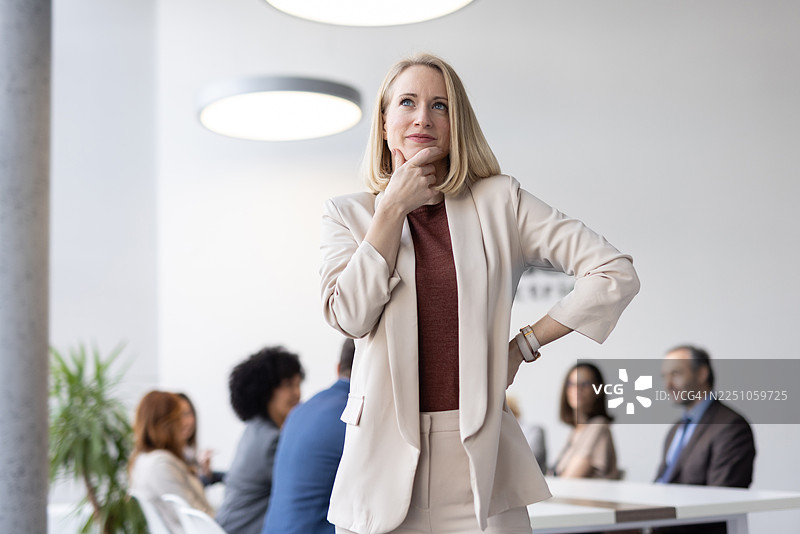 一位穿着时尚的职业女性在办公室沉思，稍作休息图片素材