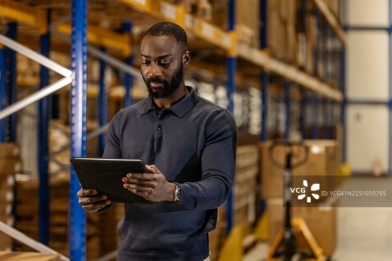 仓库工人使用数字平板电脑进行库存管理图片素材
