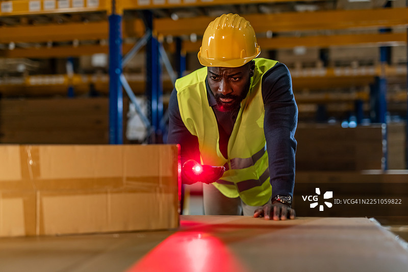 仓库工作人员在工业仓储设施内使用激光扫描包裹图片素材