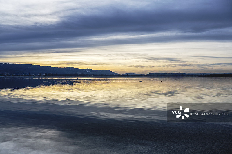 傍晚的灯光，水面倒影，在德国巴登-符腾堡州康斯坦茨区博登湖畔的拉多尔夫采尔附近图片素材
