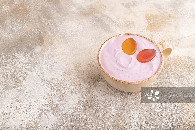 紫色的酸奶，上面放着果冻糖，背景是棕色混凝土，侧面视角，留有复制空间，极简风格图片素材