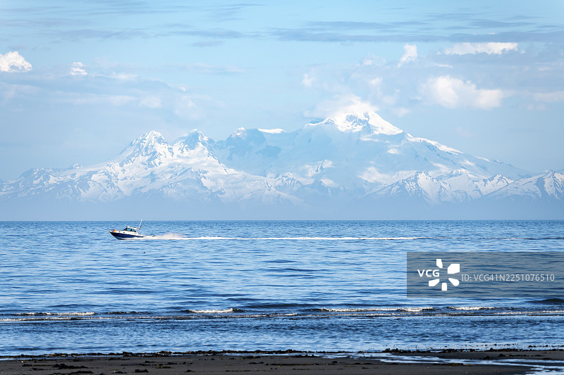 从库克湾远眺伊利亚姆纳火山的白色山峰，海上的摩托艇，阿留申山脉，锚点，锚河州立娱乐区，阿拉斯加，美国图片素材