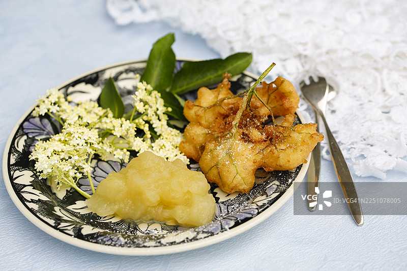 施瓦本美食，接骨木莓蛋糕配苹果酱，Hollerkiacherl（接骨木花煎饼），酥皮接骨木花，甜点，甜点，油炸，盛在盘子里，奶奶的厨房，地方特色，家常菜，典型的施瓦本风味，经典食谱，传统美食，美食摄影图片素材