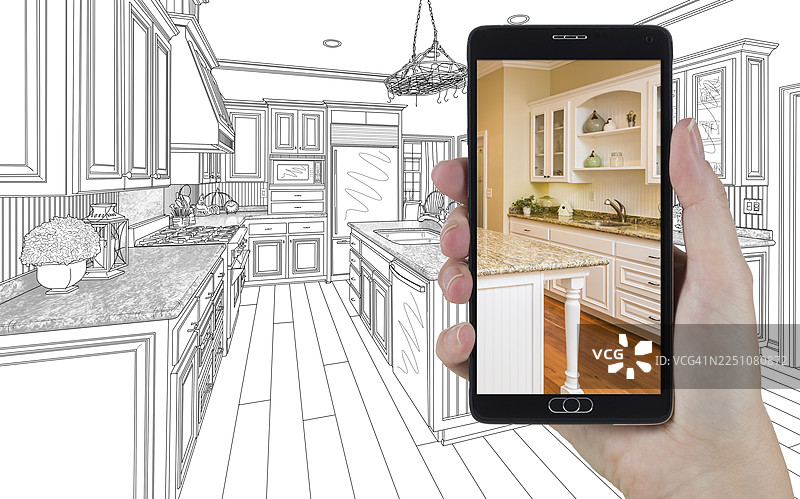 手持智能手机，屏幕显示着定制厨房图纸的图片图片素材