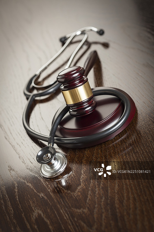 木制反光桌上的法槌和听诊器图片素材
