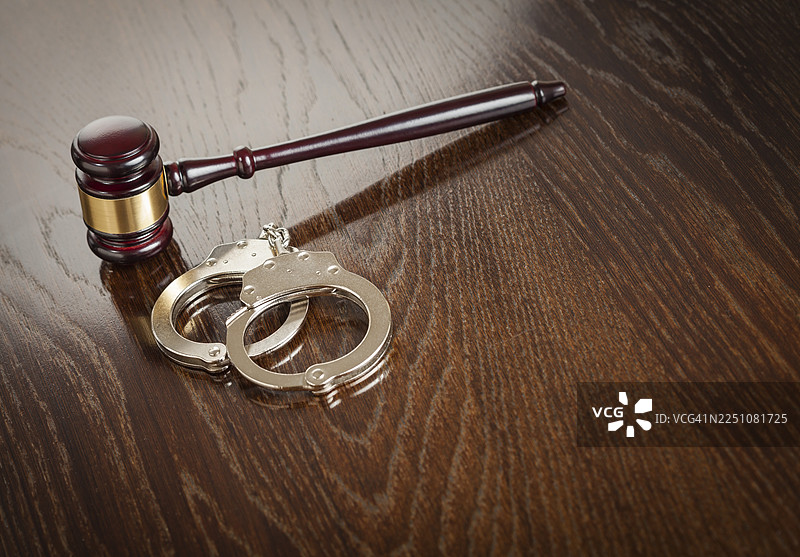 木桌上的法槌和一副手铐图片素材
