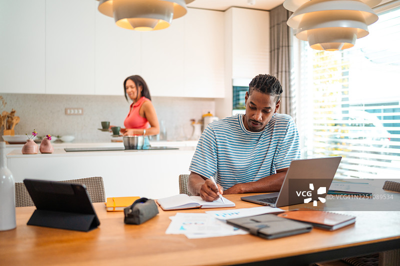 中龄夫妇在明亮的厨房环境中审阅财务状况图片素材