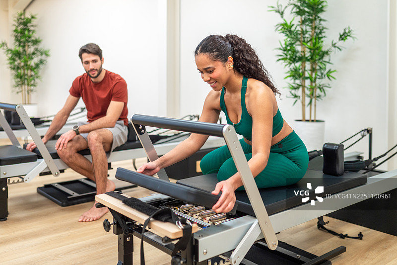 年轻的西班牙裔女性正在进行普拉提器械训练图片素材