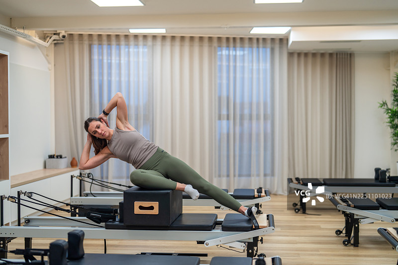 年轻的高加索女性运动员在工作室进行普拉提练习图片素材