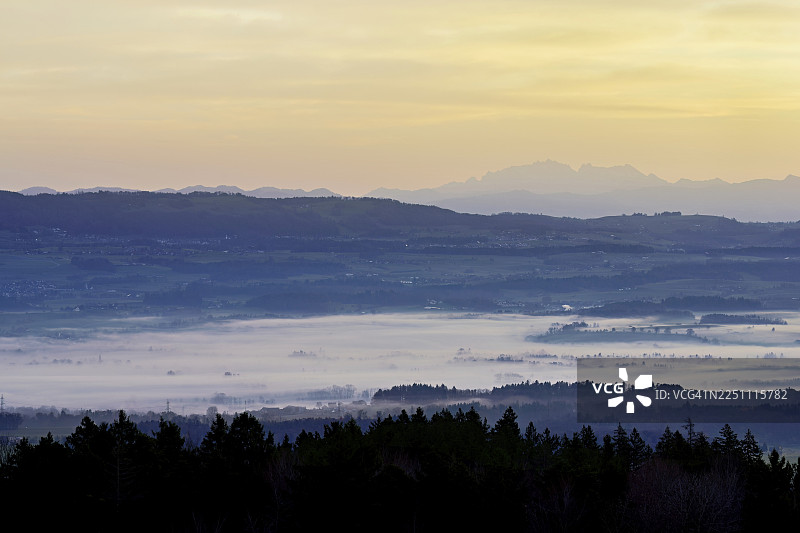 从霍本看到的被大雾笼罩的罗伊斯河谷,其后是阿尔卑斯坦山脉和升起太阳下的桑蒂斯峰,位于瑞士阿尔高州拜因维尔-弗赖阿姆特。图片素材