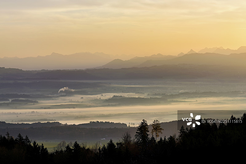 从霍尔本眺望被雾气笼罩的罗伊斯河谷，背景是初升阳光下的格拉鲁斯阿尔卑斯山，位于瑞士阿尔高州拜因维尔-弗赖阿姆特。图片素材