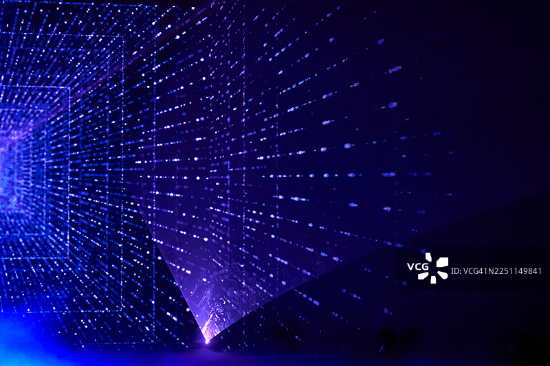 黑暗场景中，未来感十足的紫色激光网格隧道，带有发光光束和数字粒子图片素材