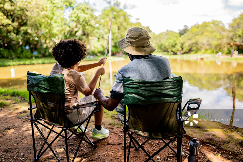 祖父和孙子在湖上钓鱼图片素材