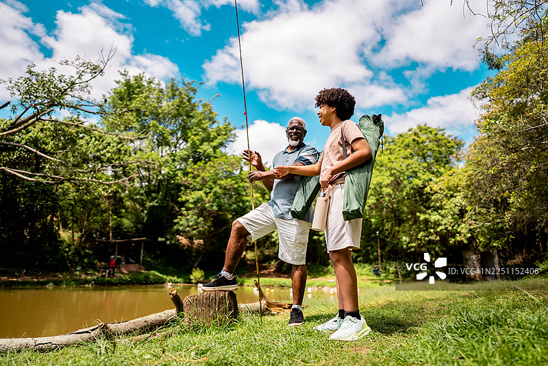 祖父和孙子在湖上钓鱼时聊天图片素材