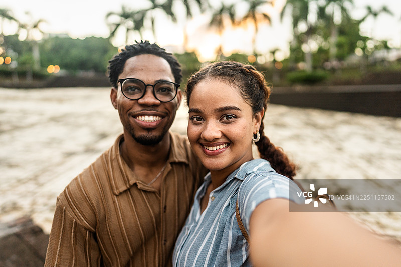 年轻的游客情侣在户外自拍——相机视角图片素材