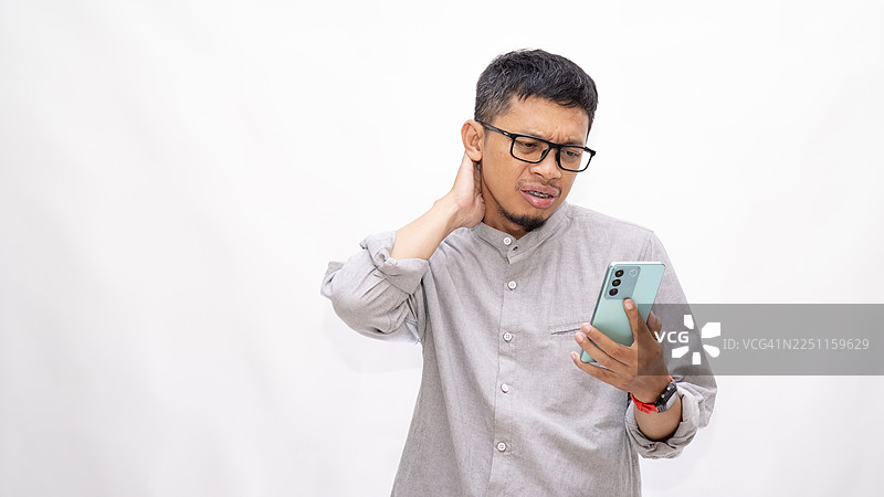 亚洲男子震惊地看着智能手机图片素材