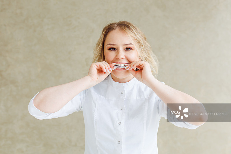 戴着牙套的女子露出灿烂笑容，在明亮休闲的环境中展示正畸治疗和健康的牙齿图片素材