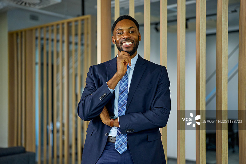 一位非裔美国商人站在现代办公室环境中图片素材