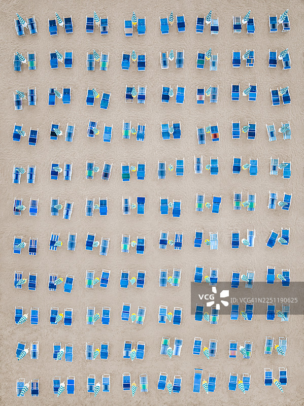 俯视拍摄，数百张蓝色太阳椅并排摆放在阿尔巴尼亚杜勒斯县杜勒斯的海滩上。图片素材