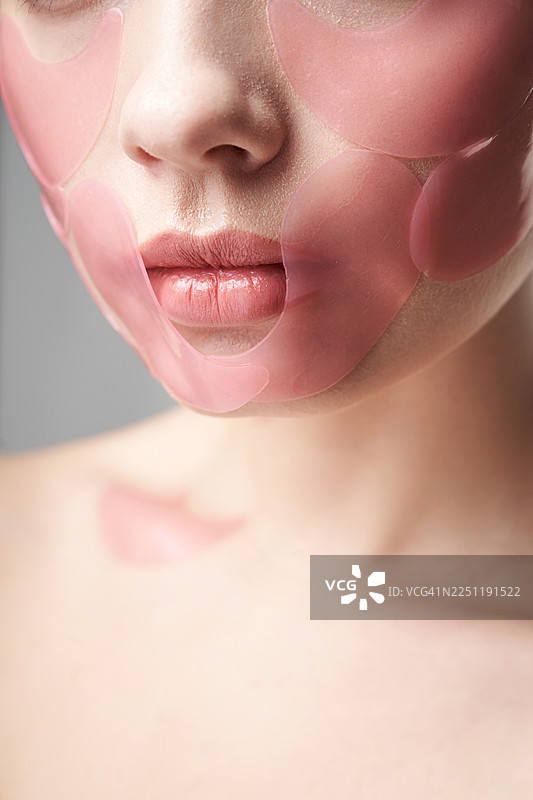 粉色水凝胶面膜的女性肖像，展现护肤、美容和呵护。图片素材