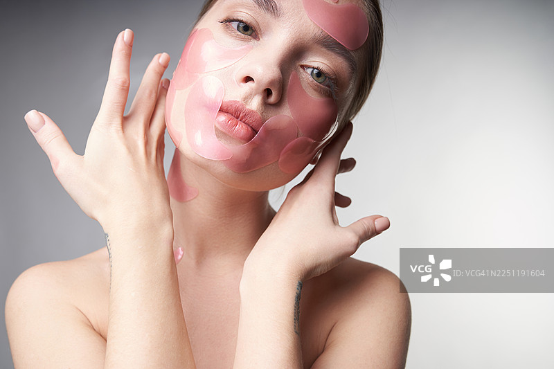 粉色水凝胶眼膜的女性肖像，展现护肤、美容和呵护。图片素材